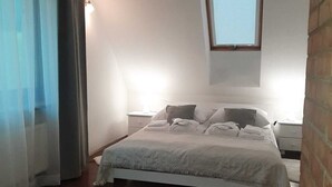 A bedroom with a bed, a window, a ceiling light, and a rug.
