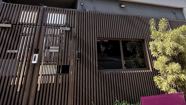 A modern building with a sloped roof, large windows, and a security gate. - Cozy Apartment for 2 (between CGH and Interlagos) (São Paulo)