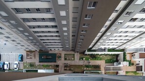 A high-rise residential building with multiple balconies, a parking area, and a landscaped courtyard. - Cozy Apartment for 2 (between CGH and Interlagos) (São Paulo)