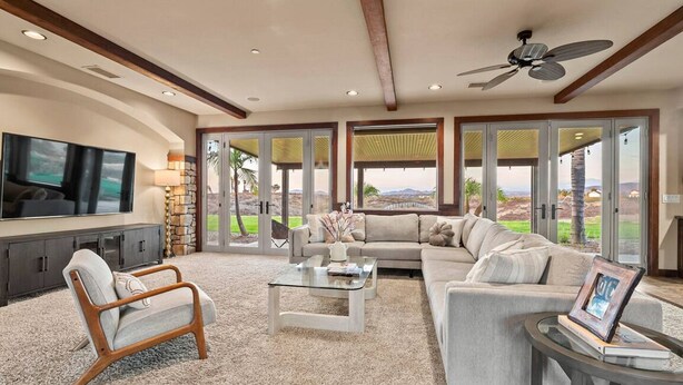 A spacious living room with a sectional sofa, a glass coffee table, and a TV mounted on the wall. - Luxe 5BR Villa / Event-Friendly & Pool Table (Temecula)
