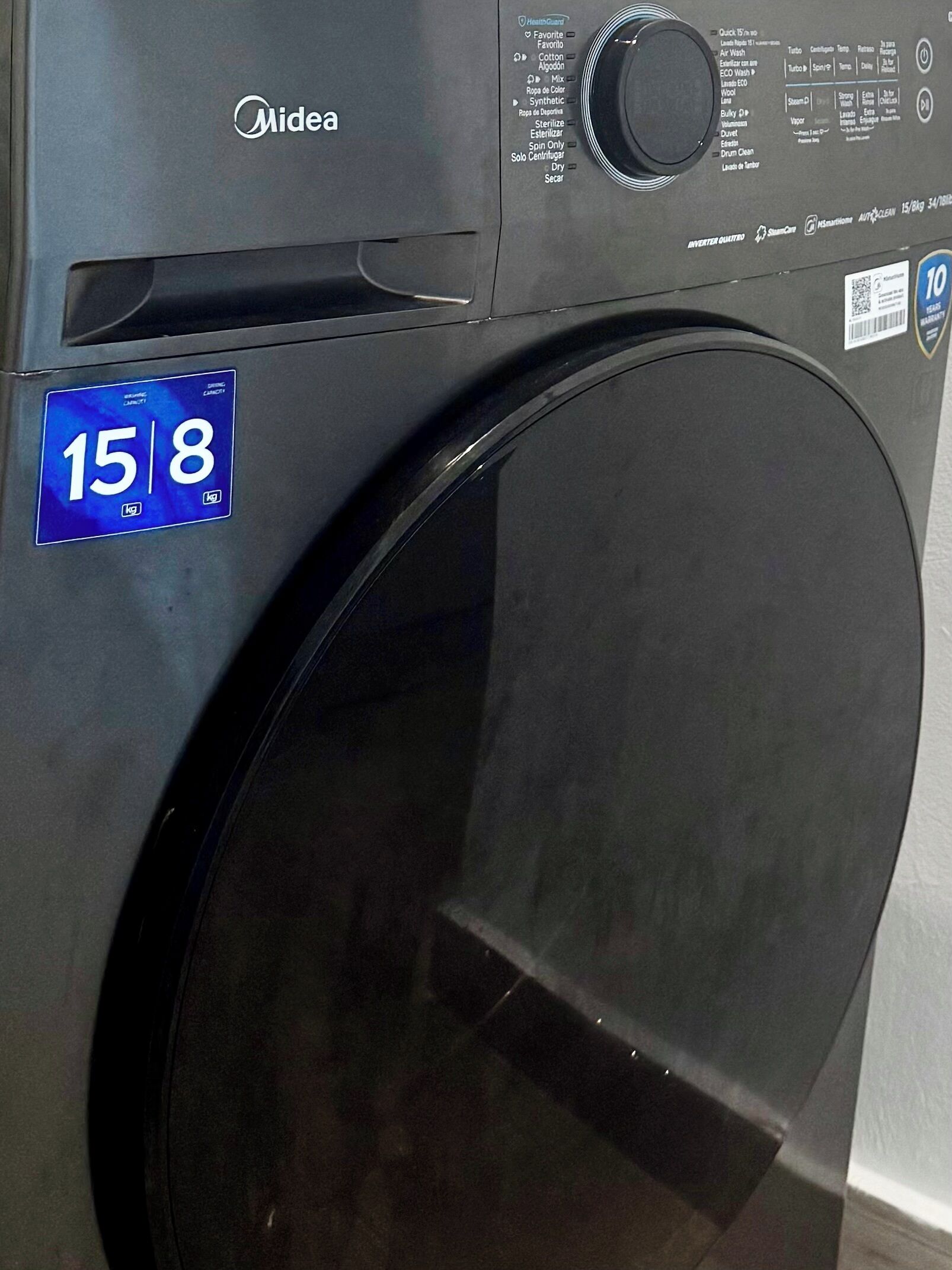 A front view of a Midea washing machine with a 15 kg capacity label.