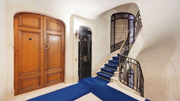 A staircase with blue carpet leading to a landing, a wooden door, and a black gate. - Superb apt A/C - 2br/6p - St Germain-des-pres (Paris)