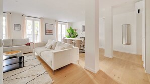 A spacious living room with a large sofa, a coffee table, and a dining area with a table and chairs. - Superb apt A/C - 2br/6p - St Germain-des-pres (Paris)
