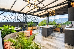 Una cocina moderna con barra, ventanas amplias y vistas a montañas.