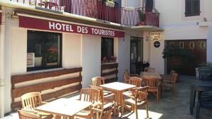 A hotel named "HOTEL DES TOURISTES" with outdoor seating and a balcony. - Hotel des Touristes (Pierrefitte-Nestalas)