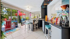 A modern kitchen with a bar area, large windows, and a pool view. - Waterfront w/ Htd Pool, Tiki Hut, Billards, & Bar (Boynton Beach)