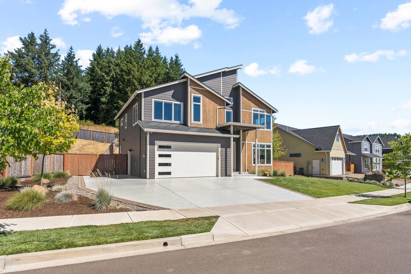A modern two-story house with a garage, a well-maintained lawn, and a suburban neighborhood.