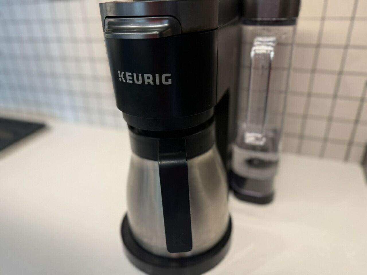Una macchina per il caffè KEURIG su un piano di lavoro in cucina.