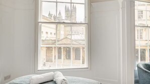 Hotelkamer met een groot raam en uitzicht op historische gebouwen.