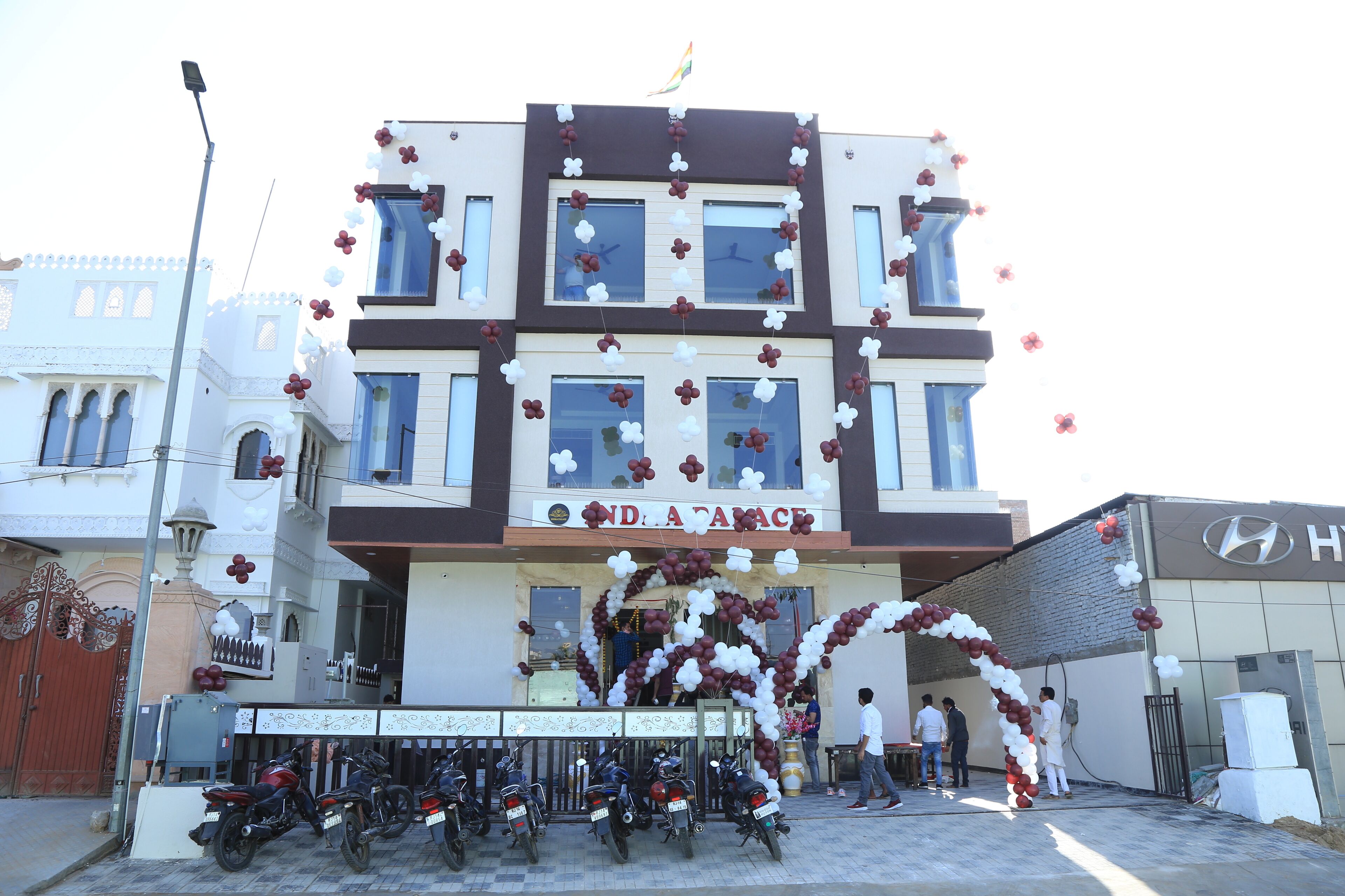 A building with a sign reading "INDIA HOUSE" and a decorative arch of balloons.