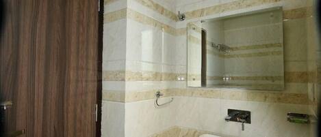 A bathroom with a wooden door, a white sink, and a mirror above it.