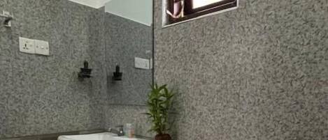A bathroom with a white sink, a toilet, and a small window.