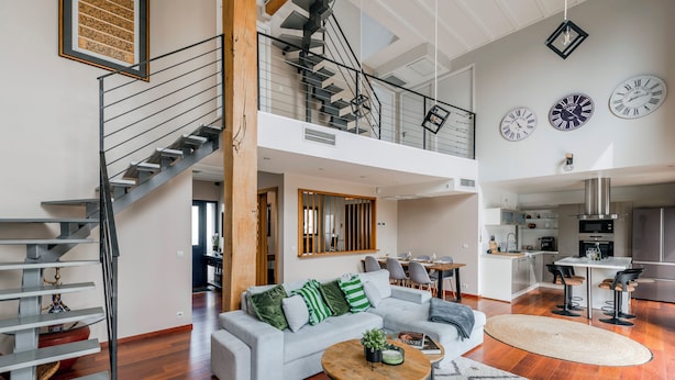 Un grand espace de vie comprenant un escalier, un coin repas et une cuisine.
