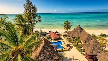 PĂ„ stranden, vit sandstrand, solstolar och parasoller