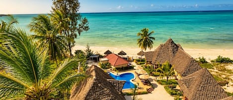 On the beach, white sand, sun loungers, beach umbrellas