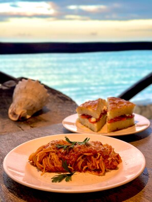 Sarapan, makan tengah hari, makan malam dihidangkan; berhadapan pantai