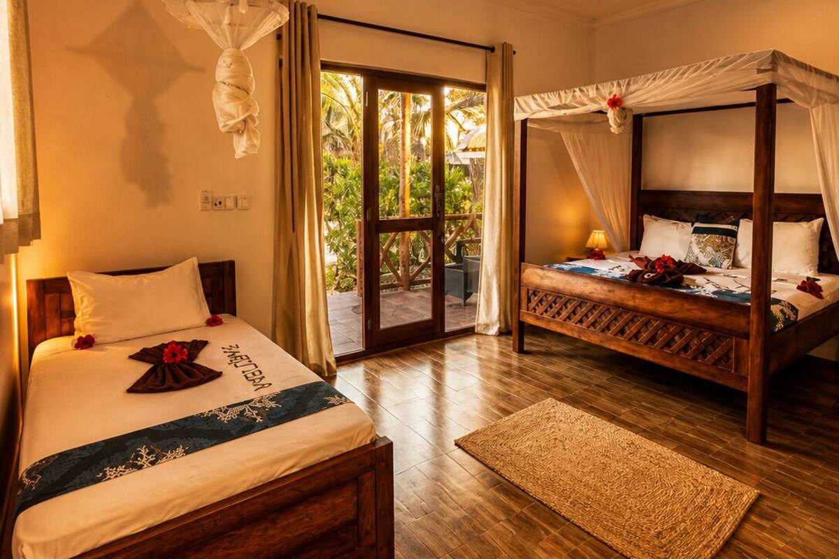 A bedroom with a bed, a canopy bed, a ceiling fan, and a view of the outdoors.