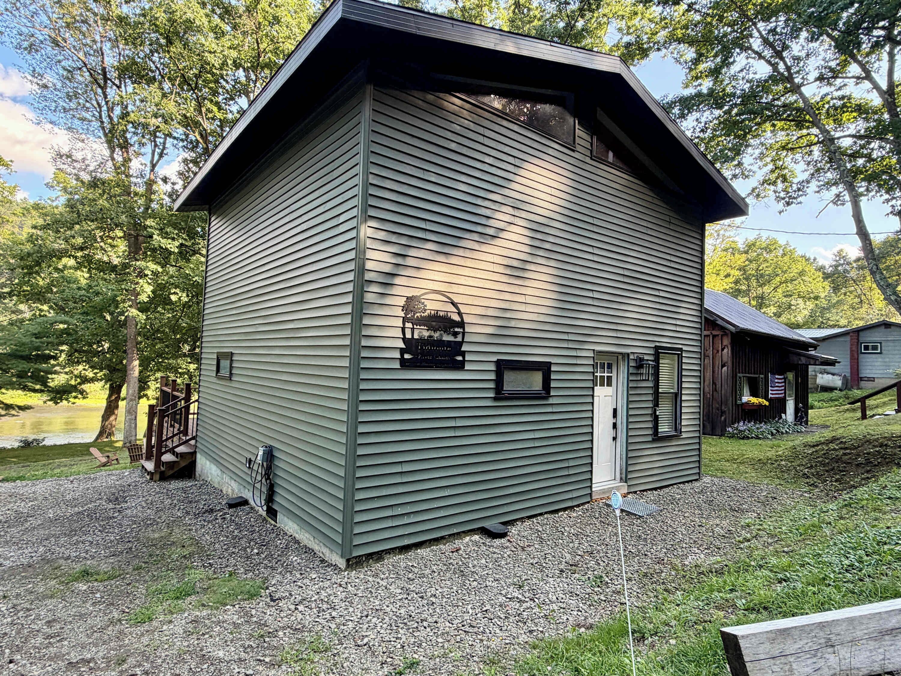 A two-story building with a sloped roof, a front door, and a small porch area.