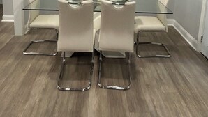 A conference room with a glass table, four chairs, and a large abstract painting on the wall. - Newly Remodeled Home with Full Deck and Gazebo. (Jackson)