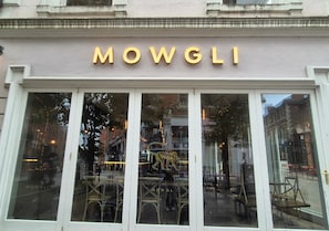 Une devanture de magasin avec le nom « MOWGLI » écrit en lettres lumineuses.