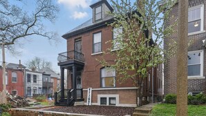 A brick building with a balcony and a 'WELCOME' sign. - Historic Tower Grove Retreat (St. Louis)