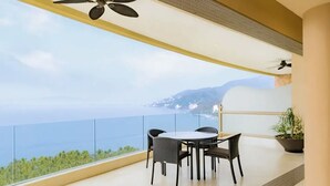 Un balcón con mesa y sillas, con vista al mar.