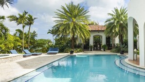 A pool with lounge chairs, palm trees, and a covered seating area. - World Cup 2026 Dream Villa 3 (Miami)