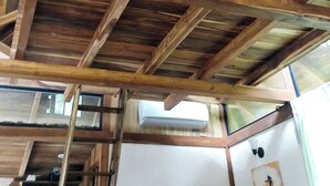 Eine Holzbalkendecke mit sichtbaren Balken und einer weißen Klimaanlage.