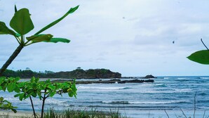 Ein Strand mit Felsformationen und einer entfernten Insel.