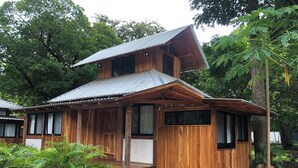 Eine Holzhütte mit geneigtem Dach, einer Veranda und einer kleinen Treppe, die zum Eingang führt.