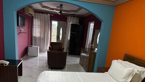 A hotel room with a bed, a desk, a chair, a wardrobe, and a bathroom. - GQ Luxury Hills Hotel- Akropong Akwapim (Akropong)