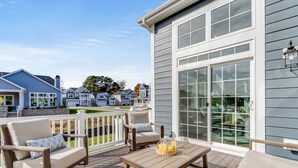 A deck with outdoor furniture, a table, and a basket of fruit. - Resort Retreat: King Suites & Nature Trails (Millsboro)