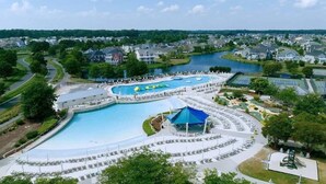 A large outdoor swimming pool with multiple lanes, surrounded by lounge chairs and umbrellas. - Resort Retreat: King Suites & Nature Trails (Millsboro)