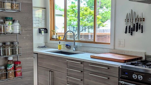 Una cocina moderna con un ventanal grande, electrodomésticos de acero inoxidable y un horno empotrado.