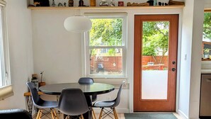 Un espacio habitable funcional con comedor, sofá y un tapete estampado.