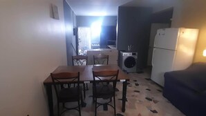 Un espacio habitable compacto con comedor, lavadora y refrigerador.