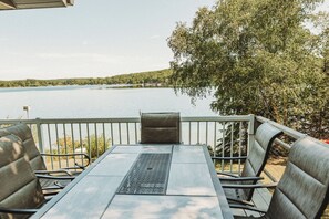 Ulkoterassi, jossa on pöytä ja tuoleja, ja josta avautuu näkymä järvelle.