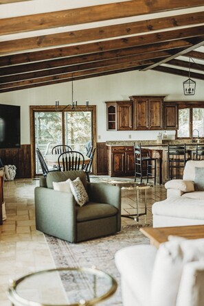 Un salón espacioso con chimenea, una mesa de comedor y una cocina con armarios de madera.
