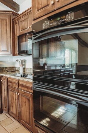 A kitchen with wooden cabinets, a stainless steel microwave, and a built-in oven. - Lilac Retreat lake house sauna + pickleball close to St. Johns and St. Bens (Saint Joseph)