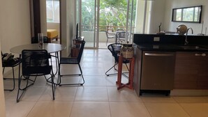 Une cuisine moderne avec un coin repas, une grande fenêtre et un ventilateur de plafond.