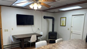 Una cocina con encimera de granito, estufa integrada, ventilador de techo y televisor de pantalla plana montado en la pared.