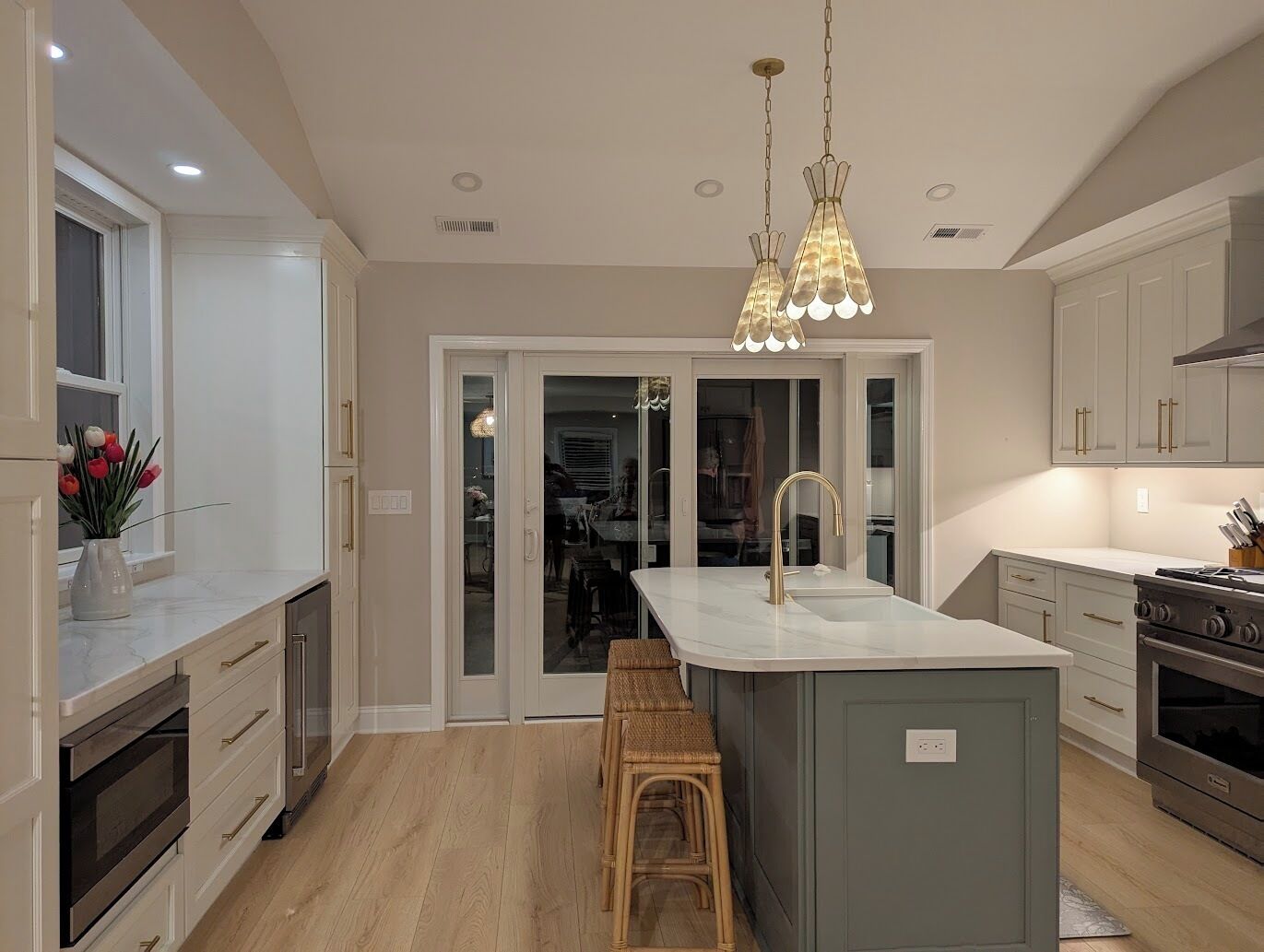 A modern kitchen with a central island, stainless steel appliances, and a pendant light.