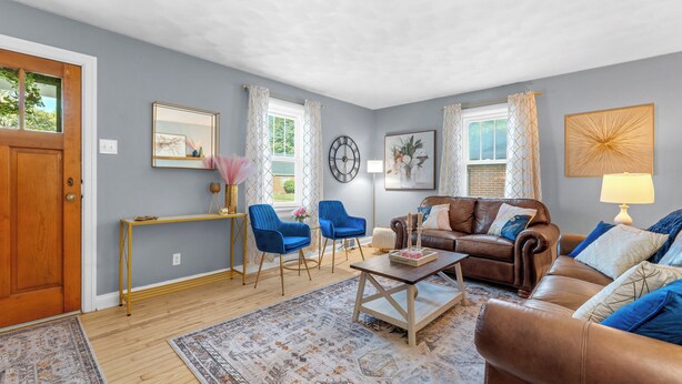 A living room with a brown leather sofa, blue chairs, a wooden coffee table, and a yellow console table. - The Yellow Haus, close to downtown Waterloo! (Waterloo)