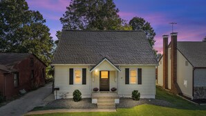 A two-story house with a gabled roof, a front porch, and a small front yard. - The Yellow Haus, close to downtown Waterloo! (Waterloo)
