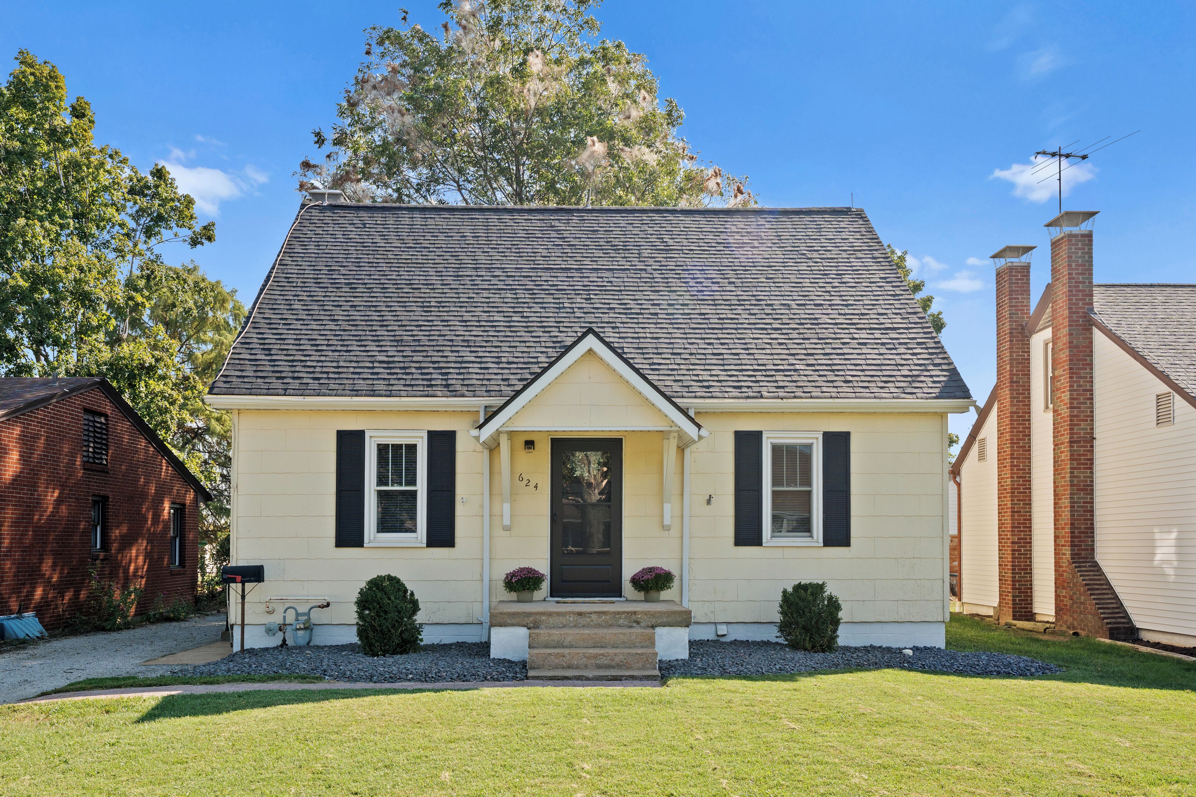 A single-story house with a gabled roof, a front porch, and a mailbox.