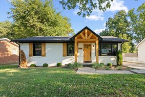 A single-story house with a gabled roof, a front porch with a wooden door, and a small front yard. - Newly Renovated Family Retreat (Franklin)