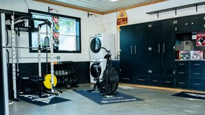 Une salle de sport équipée de matériel de musculation, d’un vélo d’appartement et d’un espace buanderie.