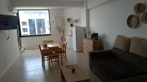 A compact living space with a dining area, kitchenette, and a sofa. - 2 Rooms Apartment, max 5 Adults, Splendid View on the Beach and the sea (Navodari)