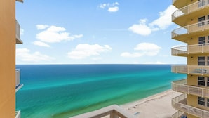 A beachfront hotel with multiple balconies, a sandy beach, and a clear view of the ocean. - Spacious 3BR/3BA Splash Condo & Amazing Gulf Views — Free Beach Chairs Included! (Panama City Beach)