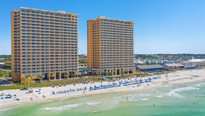 A coastal hotel with multiple floors, a beach with umbrellas, and a clear view of the ocean. - Spacious 3BR/3BA Splash Condo & Amazing Gulf Views — Free Beach Chairs Included! (Panama City Beach)